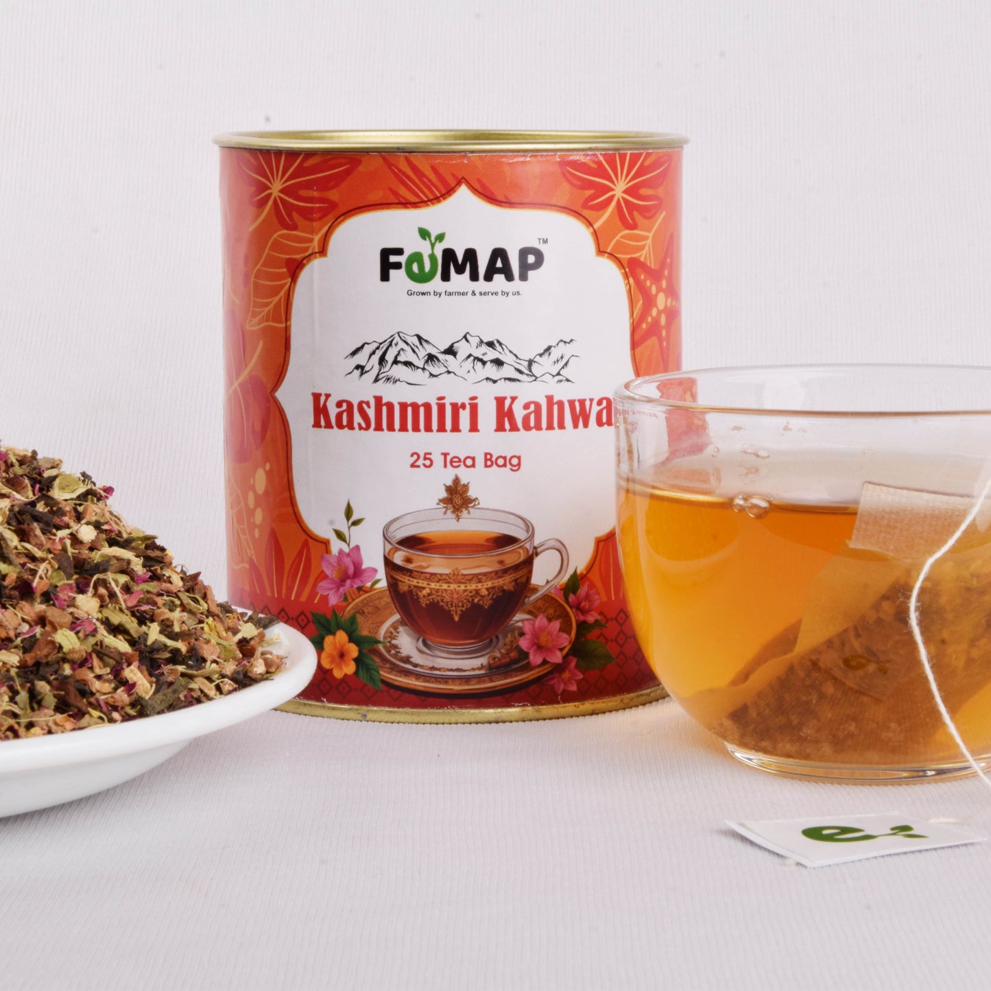 FEMAP Kashmiri Kahwa tea tin with loose tea leaves in a bowl and a glass cup containing brewed kahwa with tea bag