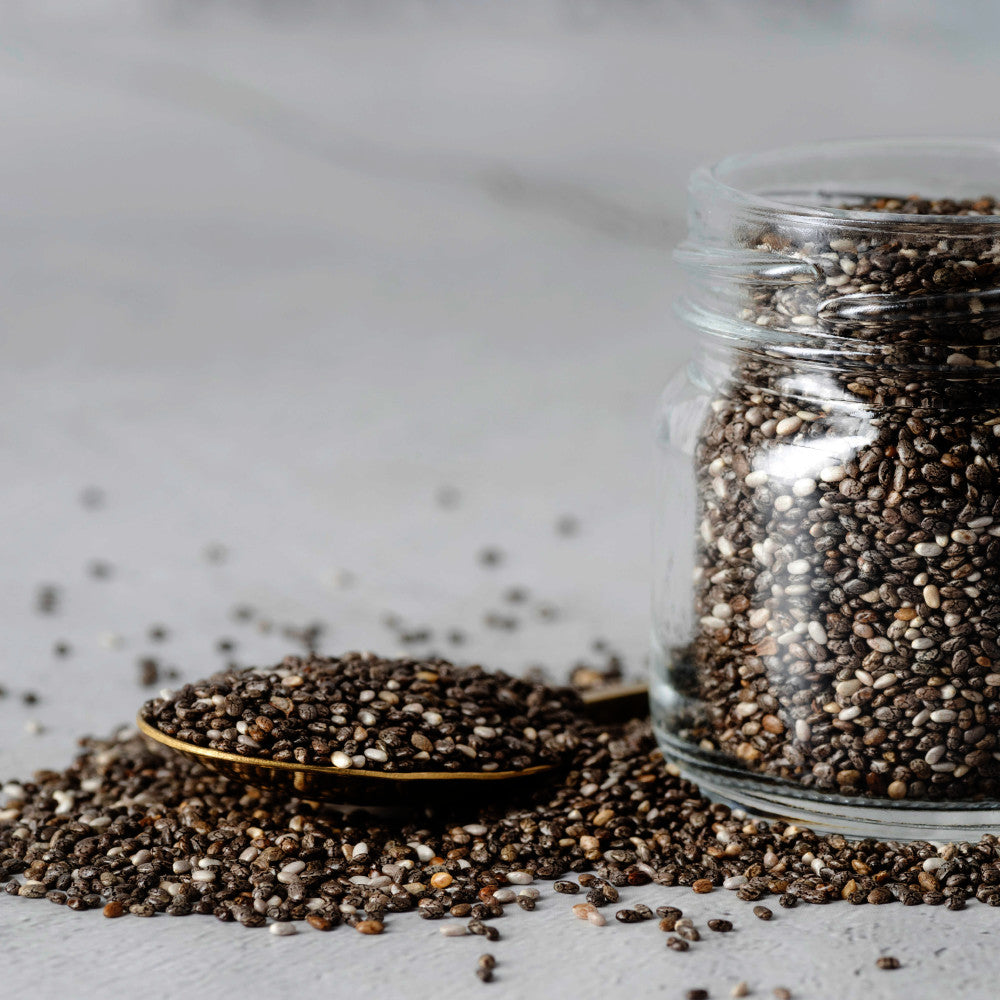 Organic chia seeds in a glass jar and spoon, rich in omega-3, fiber, and protein for healthy diet and superfood nutrition