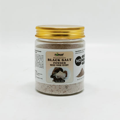 Jar of black salt powder with a gold lid on a white background
