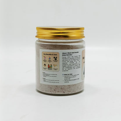 Jar of black salt powder with a gold lid on a white background