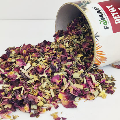 Close‑up of ingredients in FEMAP detox tea – lemongrass, rose petals, ginger, cinnamon and other herbs outside the box