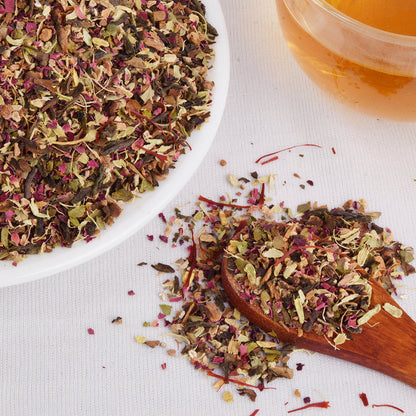 Cup of brewed Kashmiri Kahwa tea with FEMAP packaging – aromatic spiced green tea steeped to golden hue.