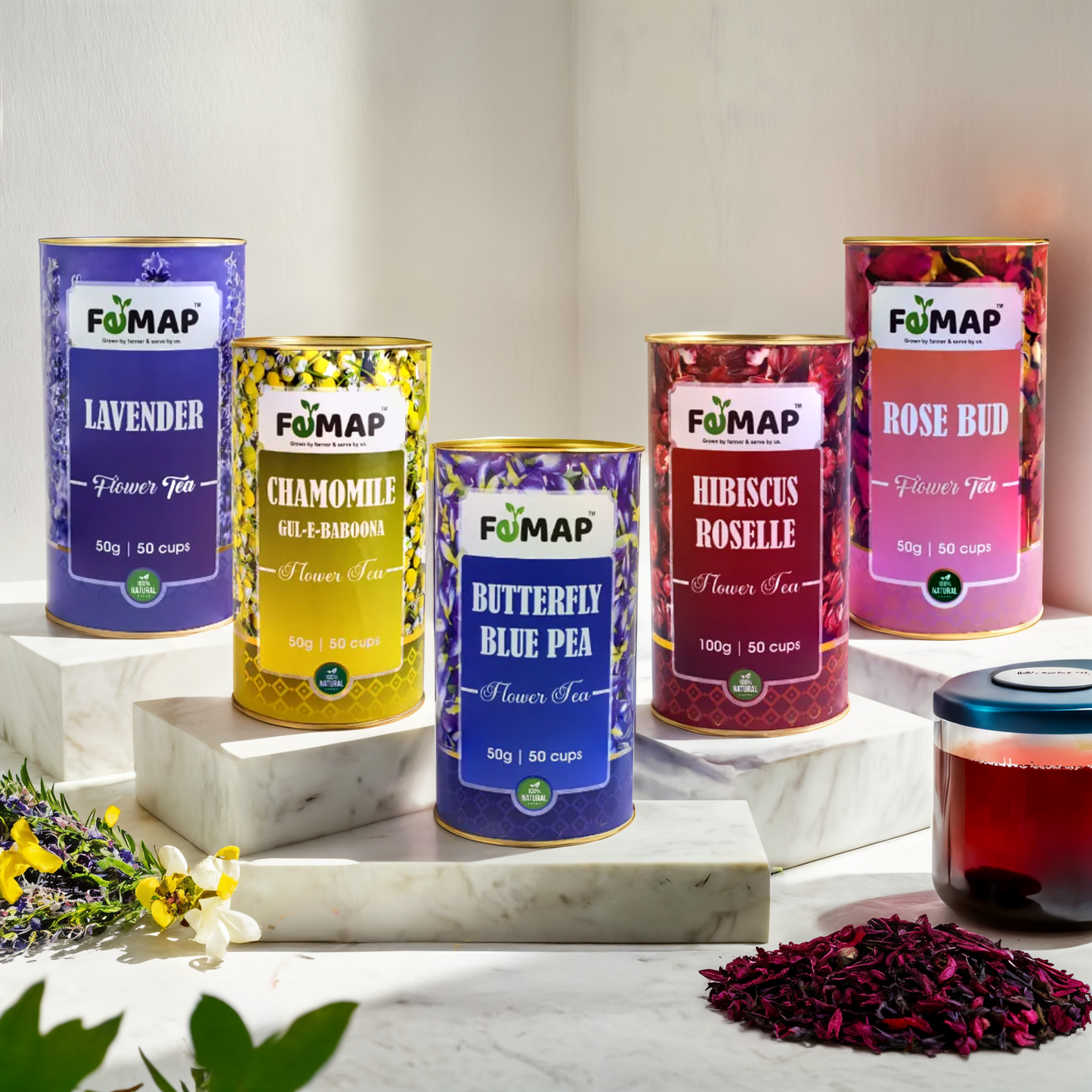 A selection of five different FEMAP branded floral teas, each in a distinctively colored tin canister. The teas include Chamomile, Hibiscus, Lavender, Rose, and Blue Tea.