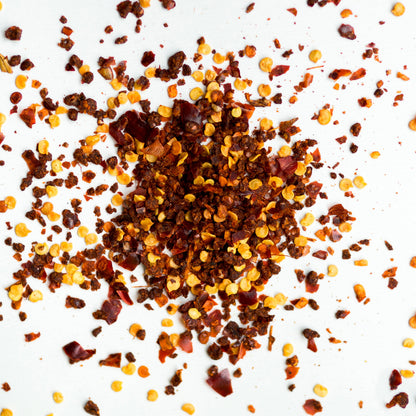 Pure red chilli flakes from FEMAP scattered on white background