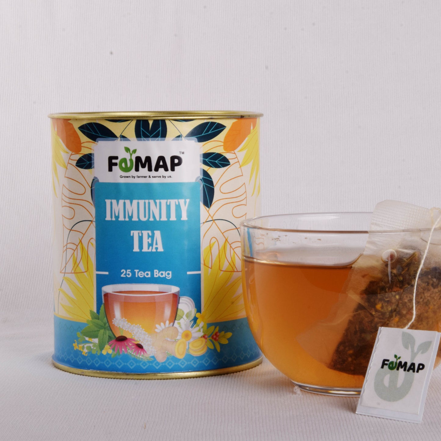 Glass teapot filled with fomap immunity tea surrounded by fresh herbs.