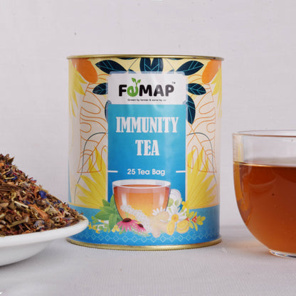 Herbal fomap immunity tea blend in a glass teapot on a wooden table.