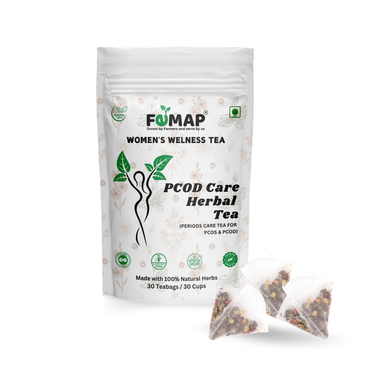 Packaging of FEMAP Women's Wellness Tea, PCOD Care Herbal Tea with two sachets of tea leaves visible in front. The packaging is predominantly white with green tea leaves and text, indicating it is a herbal tea product.