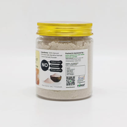 Jar of fine rock salt powder with a yellow lid on a white background