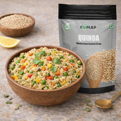 Bowl of quinoa salad with vegetables, FUMAP quinoa package, and a scoop of quinoa on a stone surface.